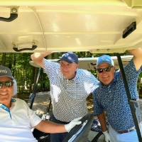Four alums on a golf cart.